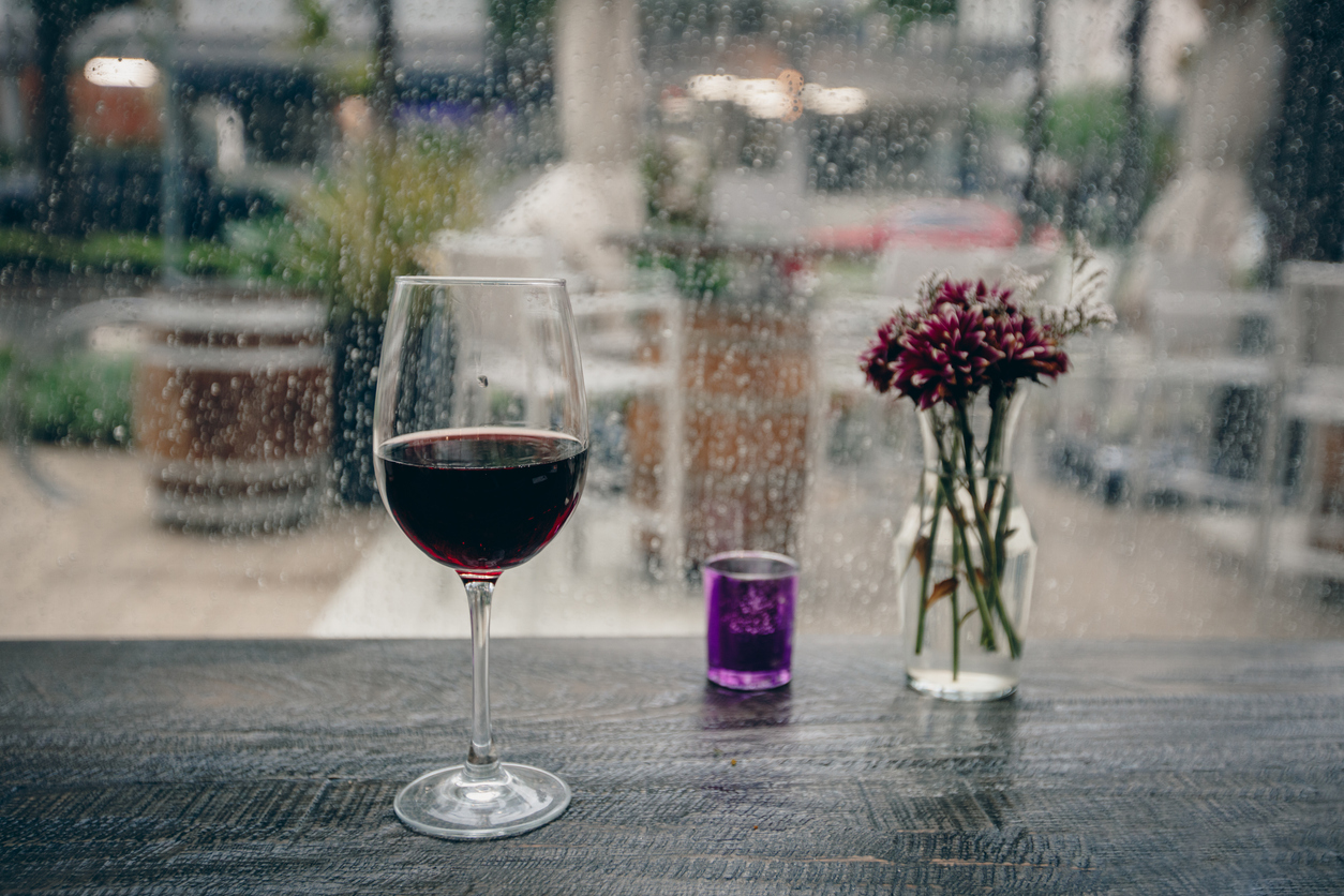 Glass of wine on a rainy day window background